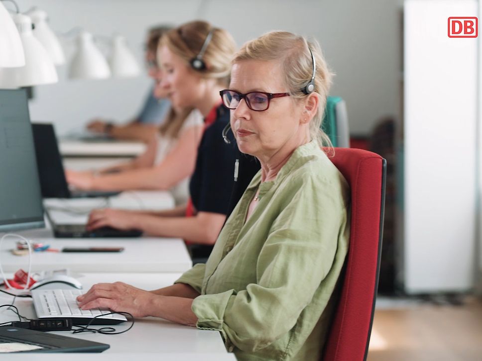Frau sitzt vor dem Arbeitsrechner und tippt auf der Tastatur